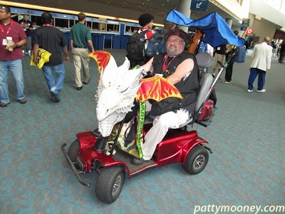 man driving red scooter on floor of san diego comic con