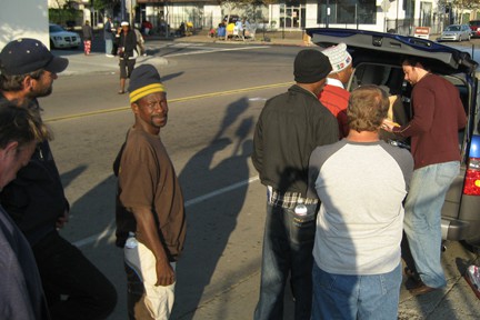 Homeless gather as citizen passes out food and water from his car downtown San Diego