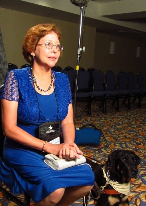 woman in blue dress seated with service dog at wounded warriors va video shoot in san diego