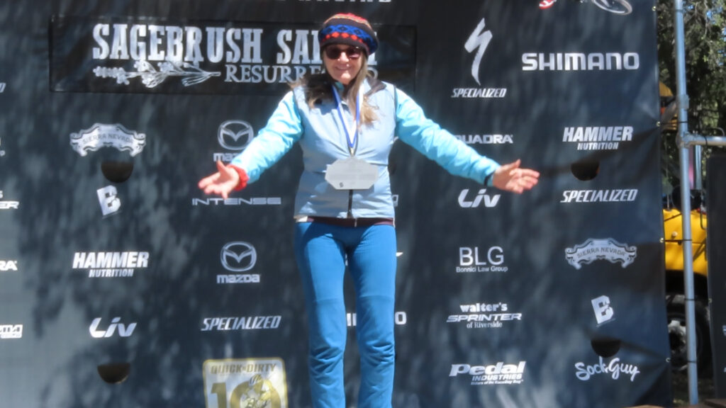 patricia mooney stands alone on podium after winning women's 20 mile mountain bike race at lake morena sagebrush safari 2023