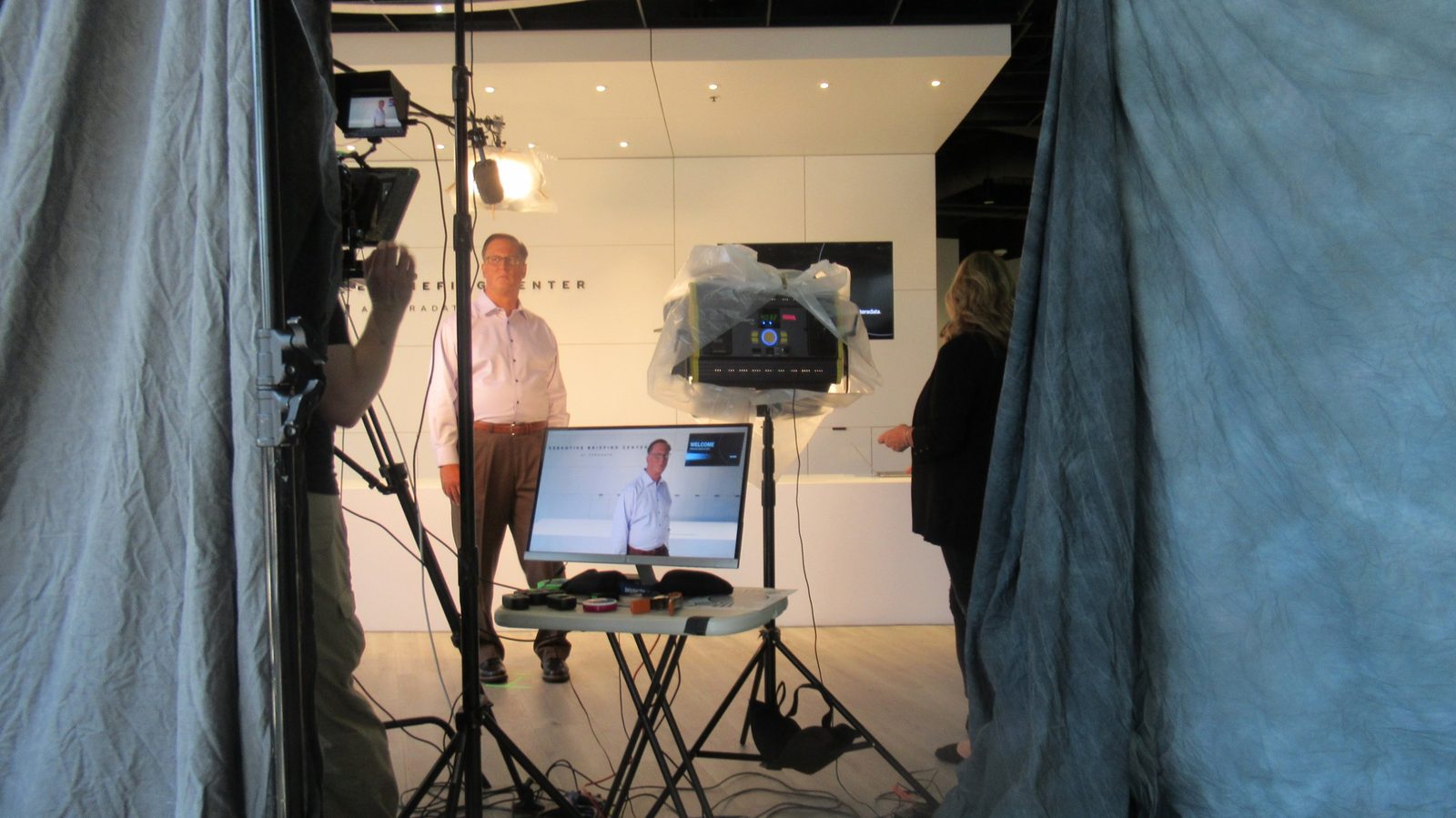 Executive filmed on location for a welcome message, with camera, LED lighting and playback monitor