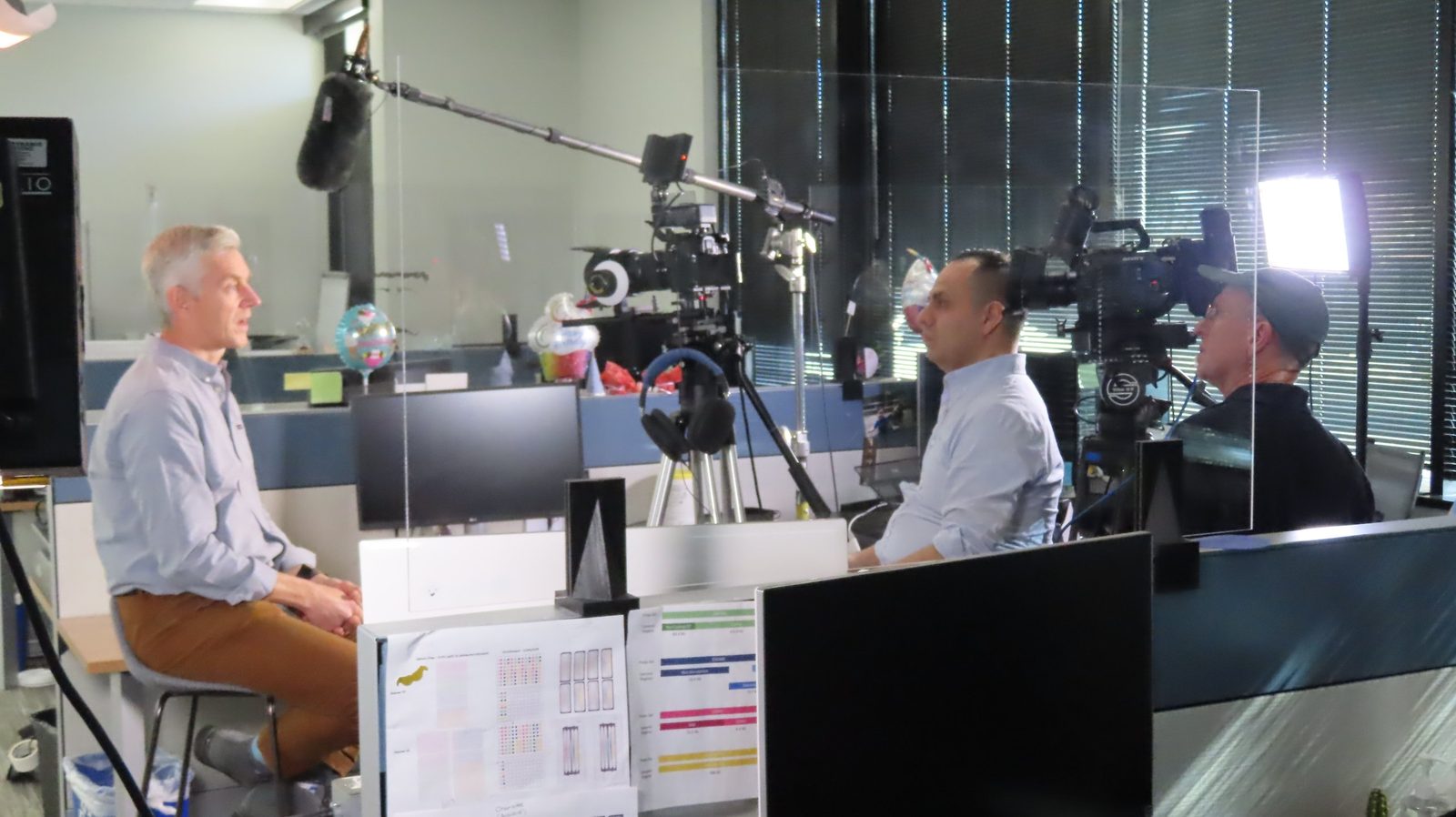Crystal Pyramid Productions crew filming a two-camera interview at Helix, a genomics company, with Sony broadcast cameras and a boom microphone