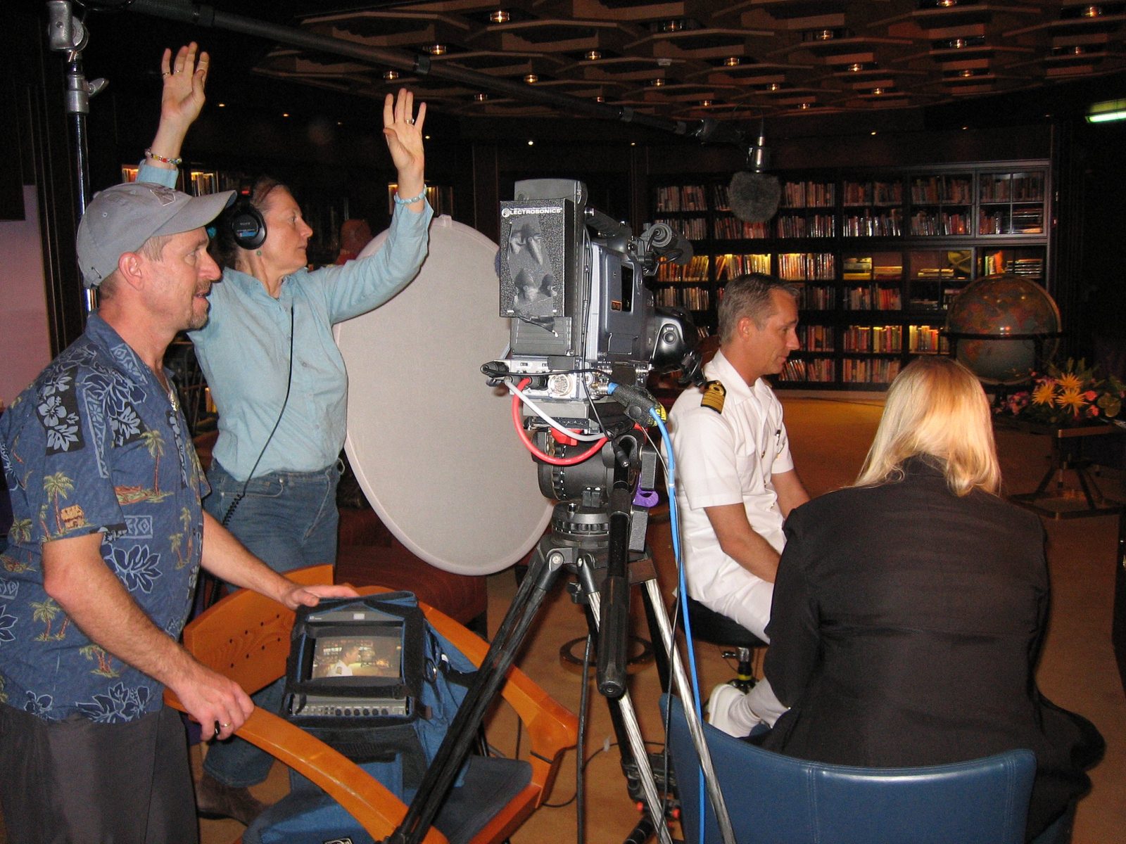 Crystal Pyramid Productions crew interviewing the captain of Holland America's Oosterdam in the ship's library